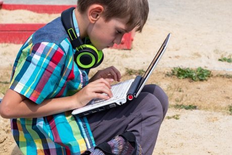 Imagini sfâșietoare! Un băiețel face cursuri online în fața școlii sale pentru că nu are internet acasă