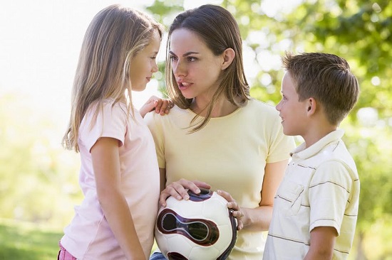 Mama cu doi copii, incercand sa discute cu fetita