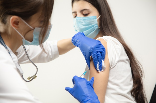 adolescenta-purtand-masca-de-protectie-in-timp-ce-este-vaccinata