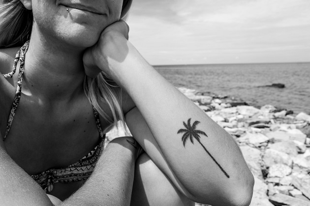 femeie-pe-plaja-ce-are-un-tatuaj-palmier-pe-mana