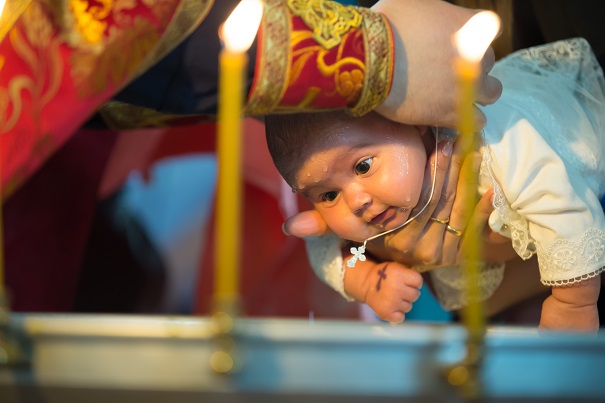 preot-ortodox-care-îi-pune-unui-copil-o-cruciulita-la-gat-in-cadrul-botezului