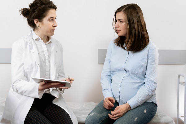 femeie tanara insarcinata discutand cu o doctorita