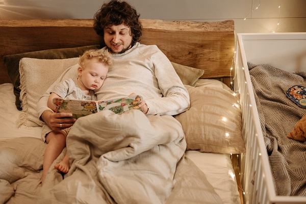 tata care îi citeste baietelului sau inainte de culcare