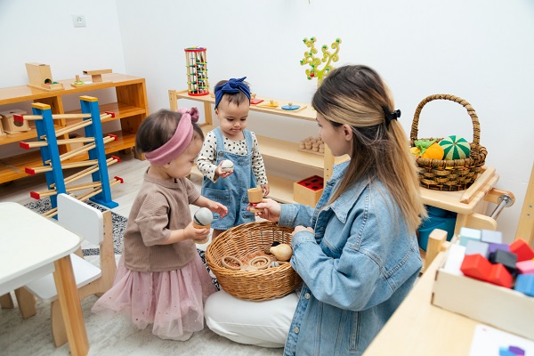 educatoare si doua fetite la o gradinita bazata pe metoda Montessori