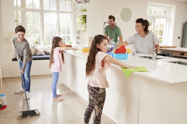 parinti si cei trei copii care se implica in treburi casnice in bucatarie