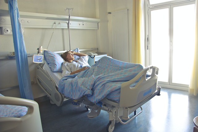 femeie pe patul de spital