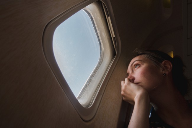 femeie intr-un avion care se uita pe geam