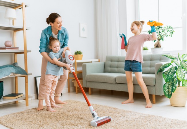 o femeie si doi copii care fac curatenie in casa