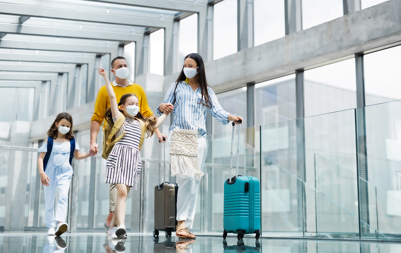 familie in aeroport purtand masca, cu bagaje