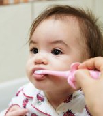 Trucul folosit de o mamă pentru a-și spăla bebelușul pe dinți. Unii spun că e genial, alții spun că e traumatizant