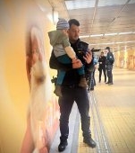 Imaginea care a topit internetul! Un băiețel de 3 ani este ținut în brațe de un agent de poliție după ce mama lui a început să aibă contracții la metrou
