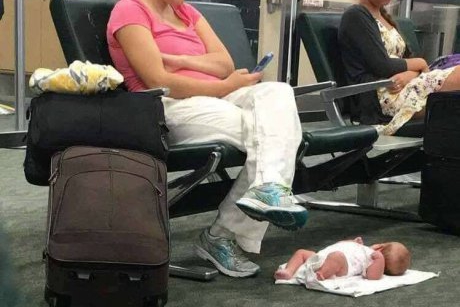 Şi-a pus bebeluşul să doarmă pe jos în aeroport în timp ce ea butona telefonul 