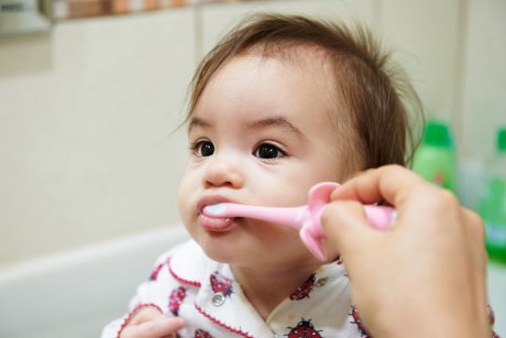 Trucul folosit de o mamă pentru a-și spăla bebelușul pe dinți. Unii spun că e genial, alții spun că e traumatizant