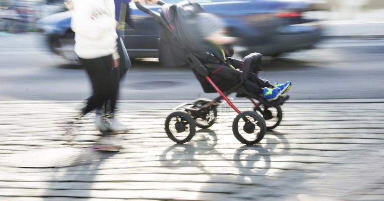 Copil plimbat în cărucior pe lângă o mașină aflată în mers!