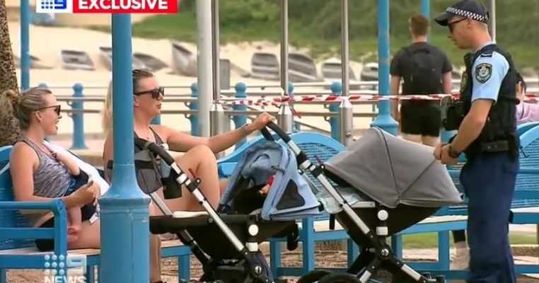 O mamă alăptând pe o bancă, stând de vorbă cu altă mamă. Normalul acum a devenit ilegal în toată lumea