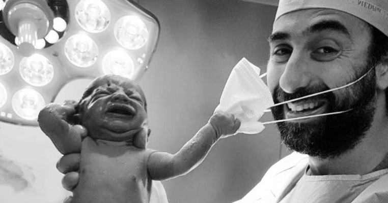 Fotografia care dă speranță umanității: nou-născutul care trage de masca medicului care l-a adus pe lume