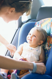 Mama asaza copilul in scaunul auto