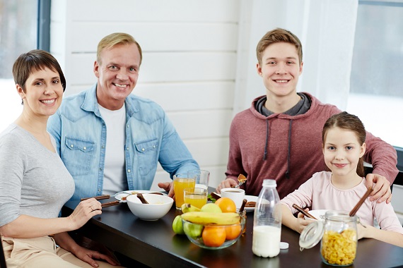 Familie formata din parinti si doi copii, la micul dejun