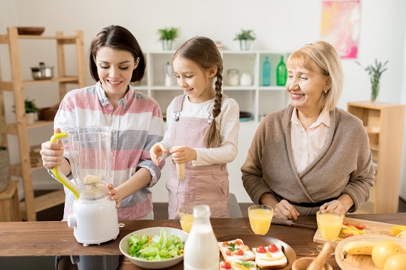 Mama, bunica si fetita pregatind un smoothie