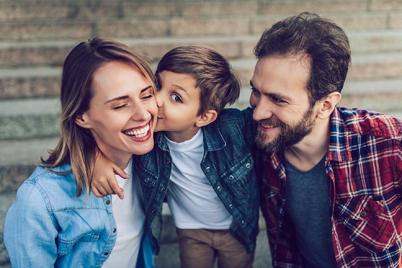 Familie fericita, copilul dandu-i un pupic mamei sale