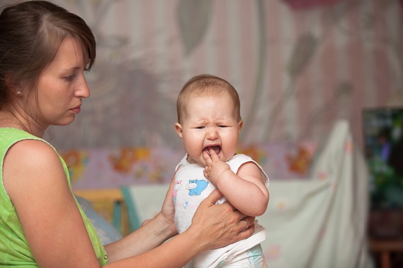 Mama care incearca sa isi calmeze bebelusul