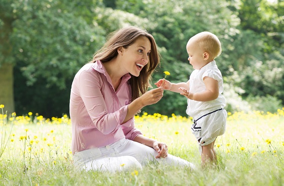 Mama ce ii ofera copilului ei o papadie