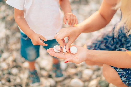 Mama ii arata pietricele copilului ei