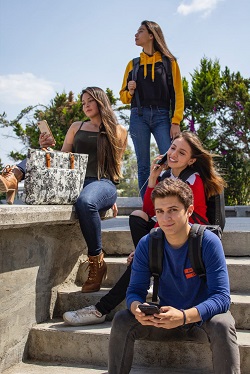 Grup de adolescenti, unii dintre ei avand telefoane mobile