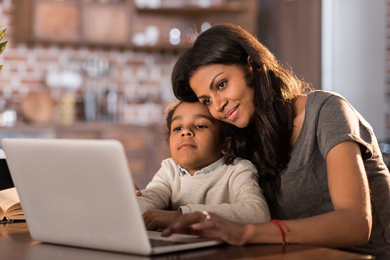 Mama si fiica ce stau in fata computerului