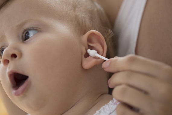 Mama ce curata urechea bebelusului cu un betisor de urechi