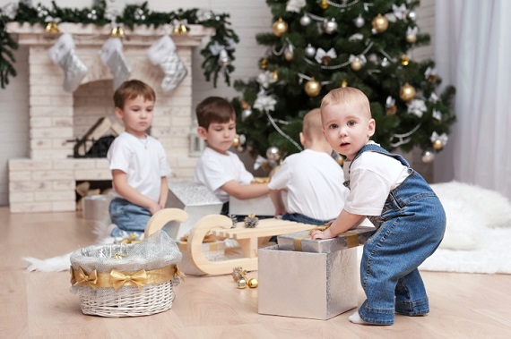 Baietel ce incearca sa scoata cadoul dintr-o cutie de cadouri