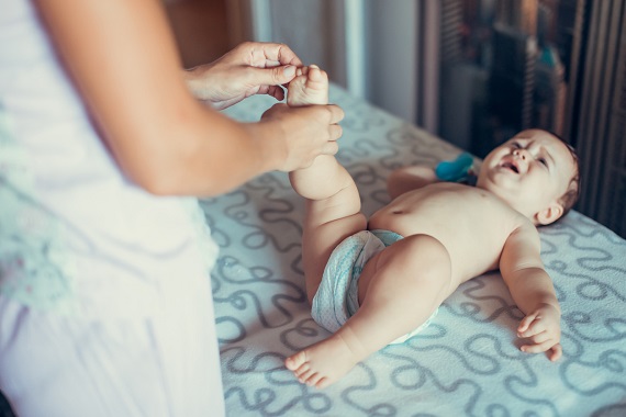 Masaj al degetelor de la picioare ale unui bebelus ce plange