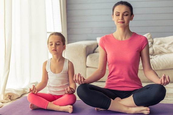 Mama si  fetita ei stau in pozitie de yoga