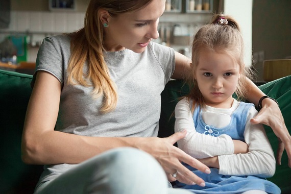 Mama care incearca sa stea de vorba cu fetita ei, care este suparata