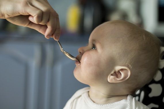 Mama ce ii da bebelusului ceva in lingurita