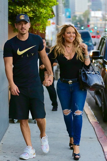 Mariah Carrey prin oras, purtand niste blugi skinny rupti in zona genunchilor