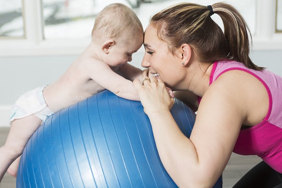 Mama ce si-a pus bebelusul pe o minge de gimnastica