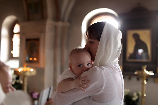 Fetita in bratele mamei sale, in biserica