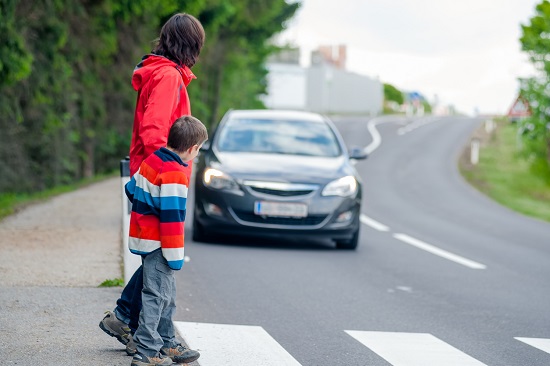 Mama ce se uita daca vine vreo masina, astfel incat sa poata  traversa in siguranta cu copilul ei