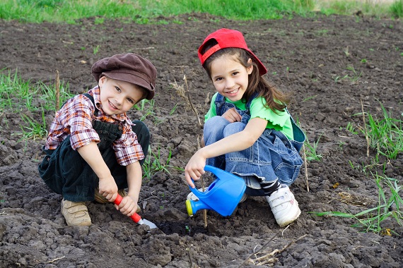 Fetita si baietel ce planteaza ceva