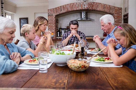 Familie la masa, spunand rugaciunea