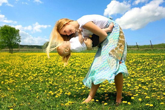 Mama se joaca pe-afara cu bebelusul ei