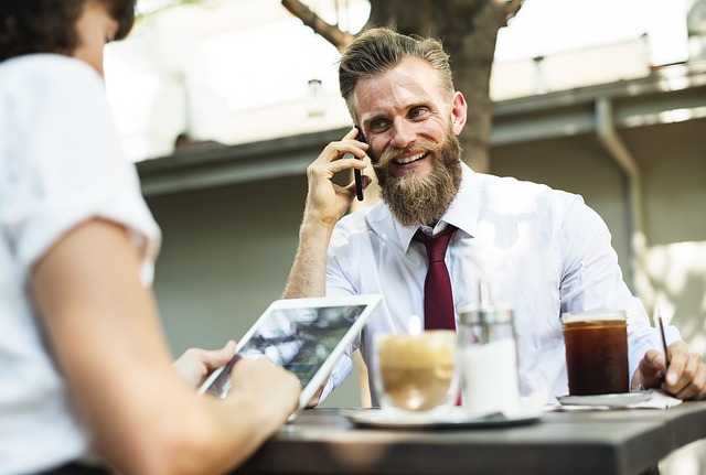 barbat care vorbeste la telefon la masa