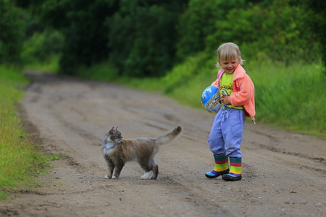 copil cu pisica in natura