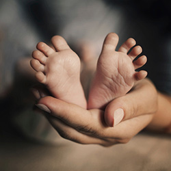 mama tine in maini piciorusele nou nascutului