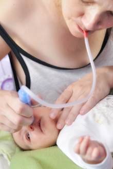 mama aspira mucozitatile din nasul bebelusului