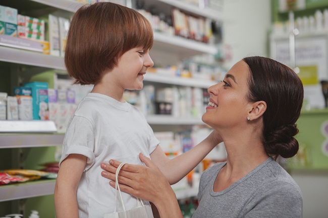 Mama si fiu ce isi zambesc unul altuia in timp ce se afla la farmacie