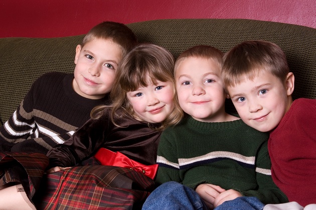 patru-copii-stand-pe-o-canapea