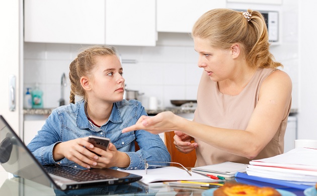 adolescenta-care-tine-in-mana-un-telefon-si-mama-ei-care-ii-explica-ceva