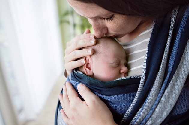 mama-care-isi-tine-bebelusul-adormit-intr-un-fel-de-marsupiu